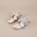 Détail du nœud en satin rose sur les ballerines enfant