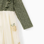 Détail de la manche en maille verte et de la jupe crème brodée de fleurs jaunes