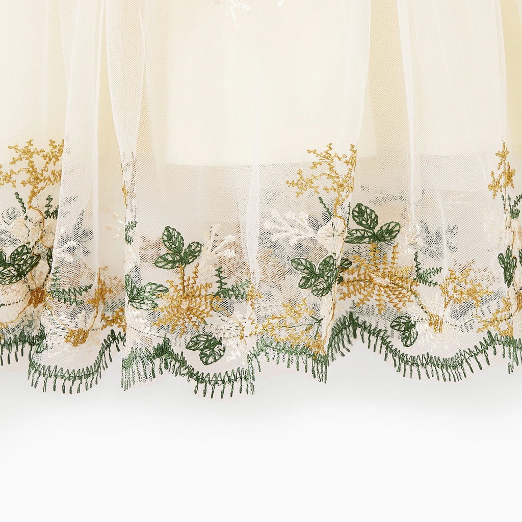 Détail des broderies florales et de la dentelle au bas de la robe automnale mère et fille