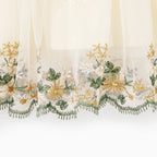 Détail des broderies florales et de la dentelle au bas de la robe automnale mère et fille