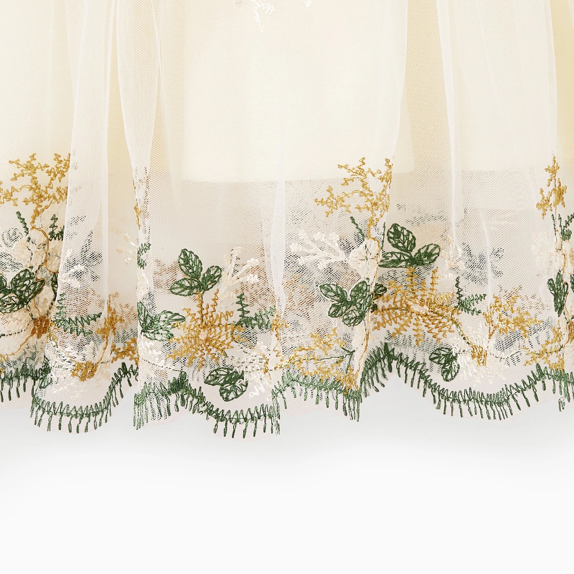 Détail des broderies florales et de la dentelle au bas de la robe automnale mère et fille