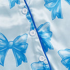 Détail tissu bleu satiné avec imprimé nœuds papillon – pyjama barboteuse bébé fille 3 mois