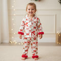 petite fille portant un pyjama de noël blanc à motifs nœuds et biscuits de pain d’épices