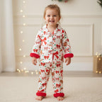 petite fille portant un pyjama de noël blanc à motifs nœuds et biscuits de pain d’épices
