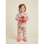 petite fille portant un pyjama de noël rose à motifs pain d’épices avec poignets en fausse fourrure rose