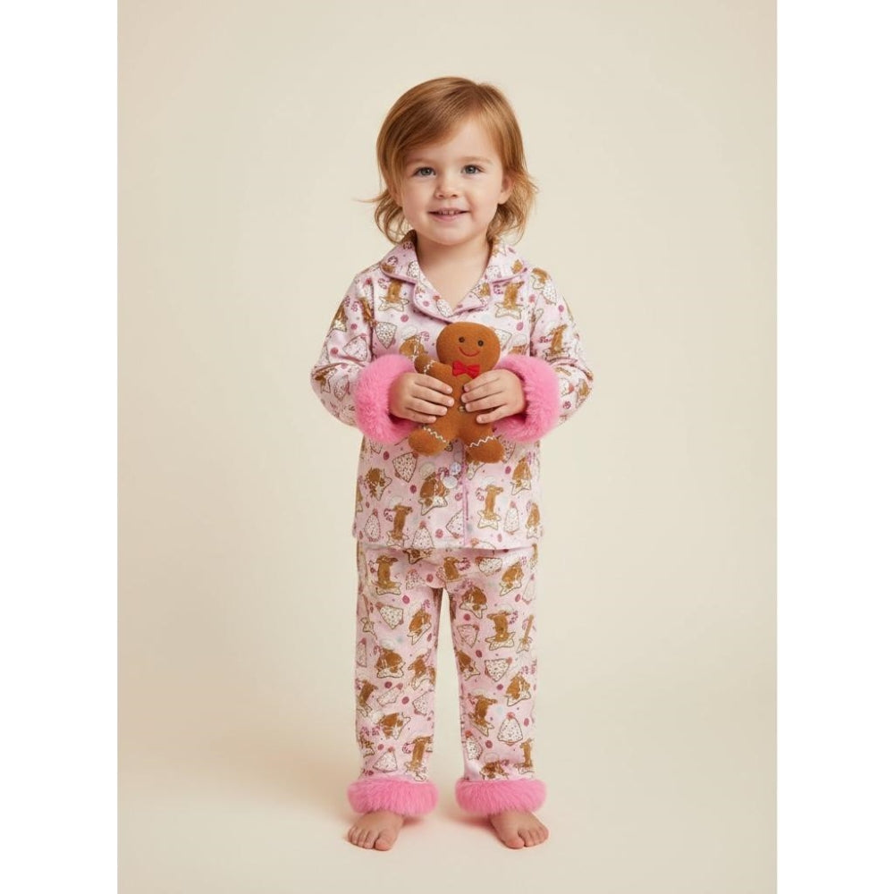 petite fille portant un pyjama de noël rose à motifs pain d’épices avec poignets en fausse fourrure rose