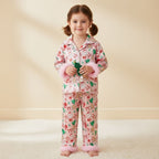 Petite fille portant un pyjama rose de Noël à motifs sucres d’orge et fourrure rose