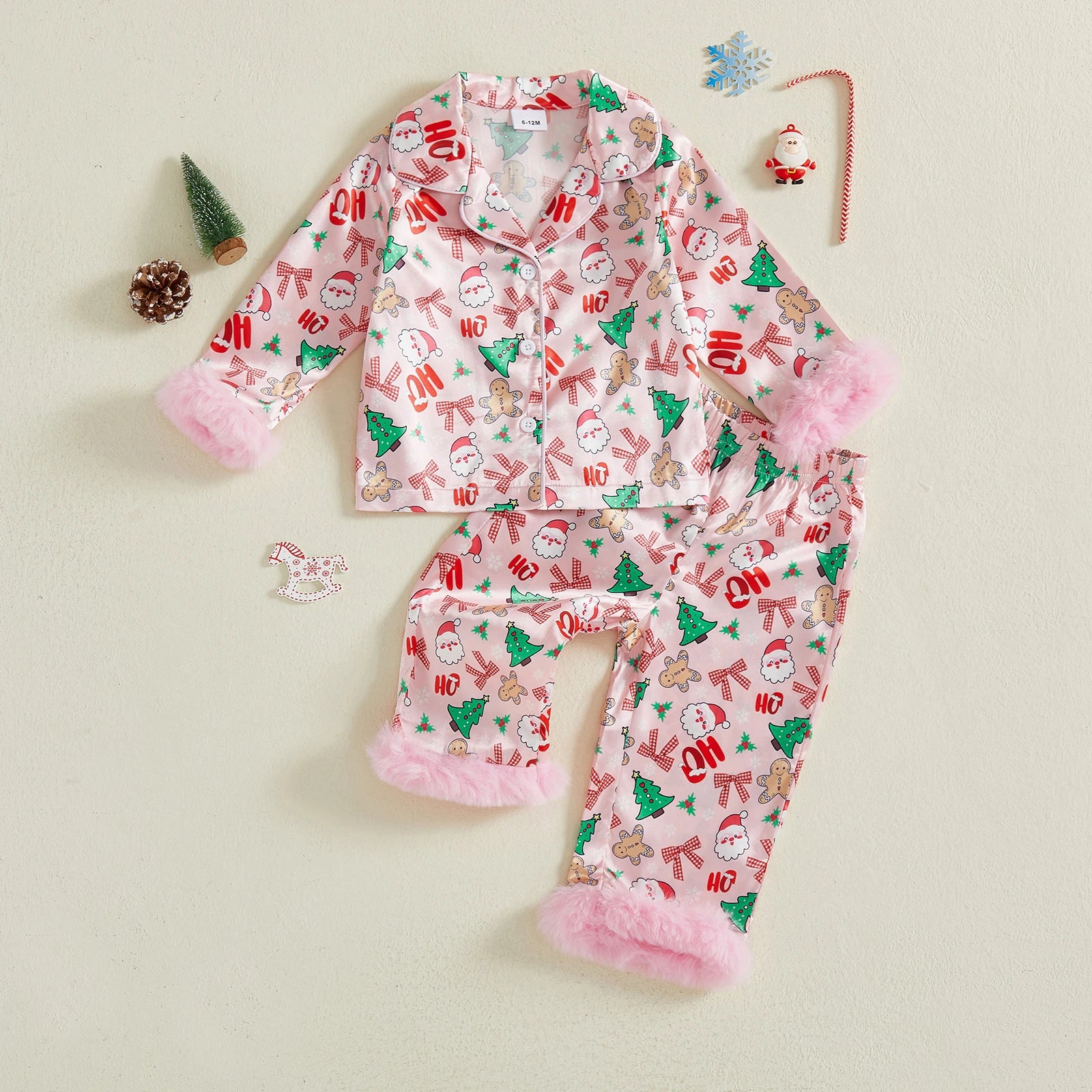 Pyjama de Noël enfant rose à motifs sapins, bonhommes pain d’épices et Pères Noël, vu de dessus