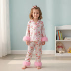 Petite fille portant un pyjama rose satiné à motifs lapins – manches et chevilles duveteuses