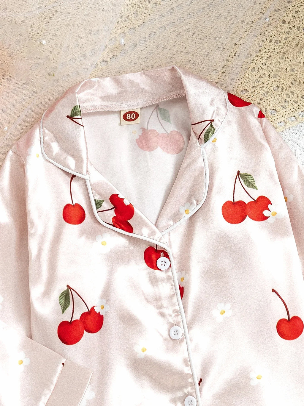 Détail col pyjama fille cerises ivoire – tissu satiné doux et brillant