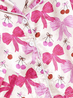 Zoom tissu pyjama fille rose nœuds et cerises – texture douce et brillante