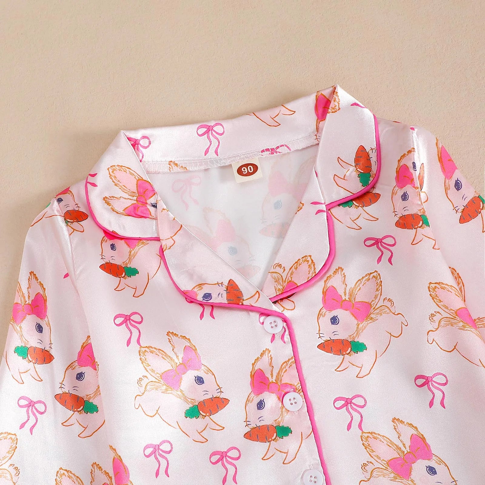 Détail du col pyjama fille lapinou – tissu satin doux et boutons blancs brillants