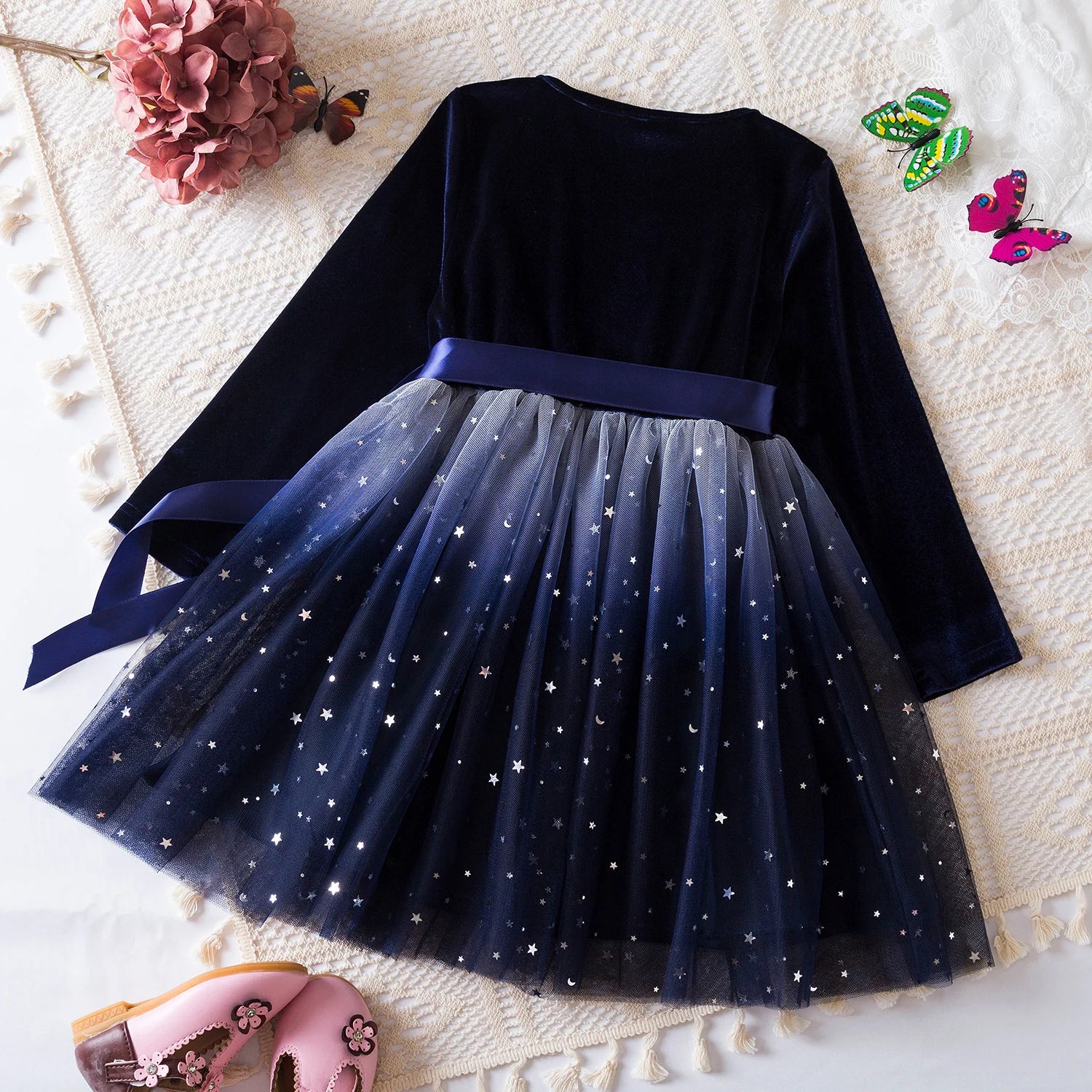 Dos de la robe bleu nuit en velours avec jupe en tulle scintillante ornée d’étoiles