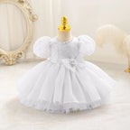 Robe bébé fille blanche à manches bouffantes et haut brodé, parfaite pour baptême ou mariage