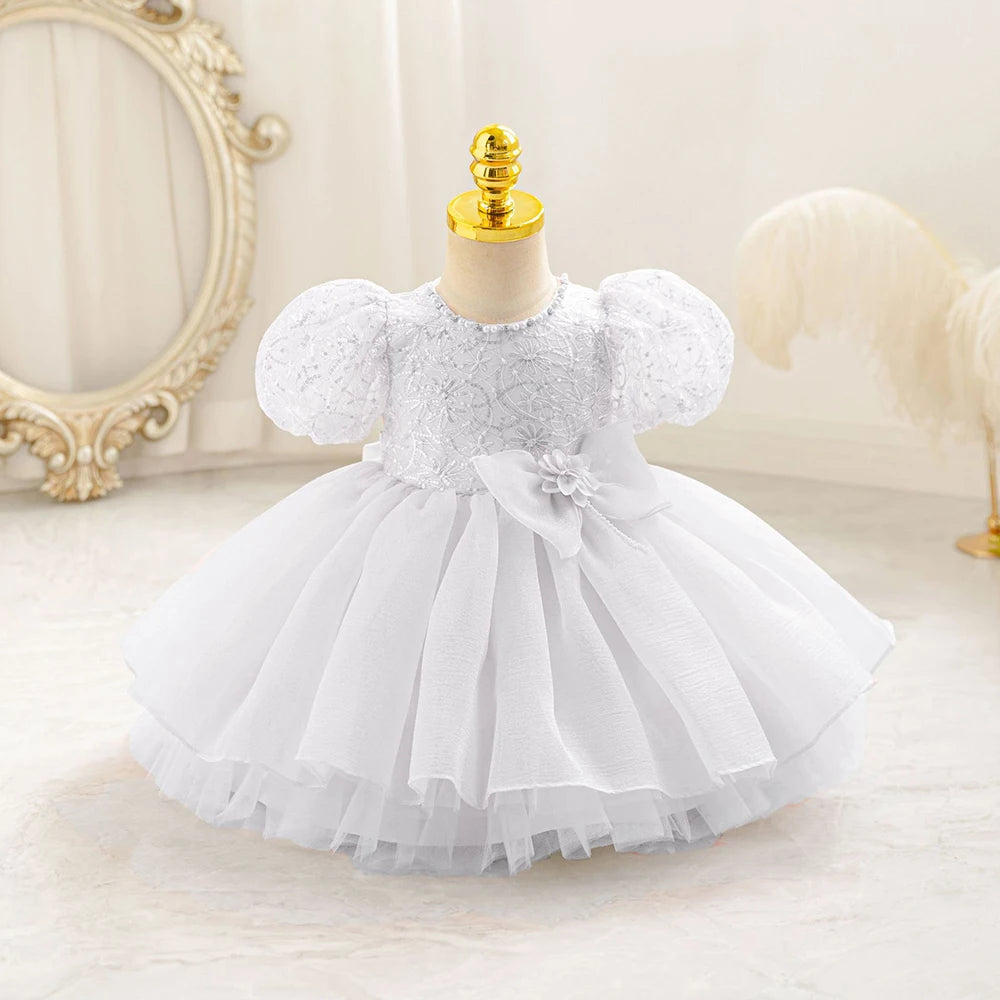 Robe bébé fille blanche à manches bouffantes et haut brodé, parfaite pour baptême ou mariage