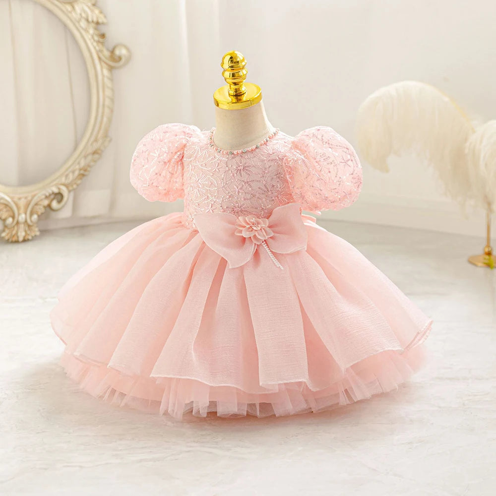 Robe bébé fille rose poudré avec haut brodé et gros nœud à la taille, douce et romantique