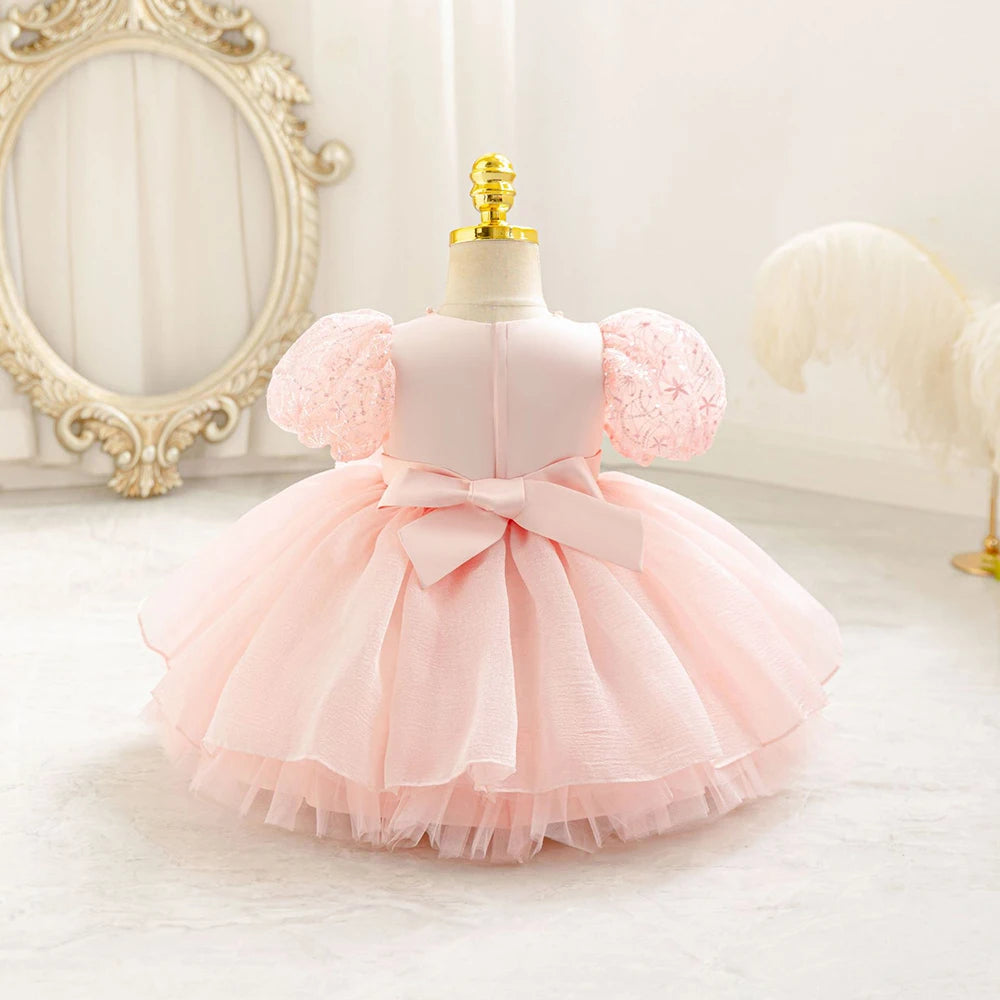 Dos de la robe bébé fille rose poudré à manches bouffantes et grand nœud plat