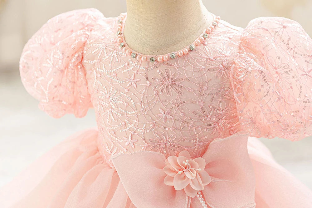 Détail du haut brodé et des manches bouffantes de la robe rose poudré