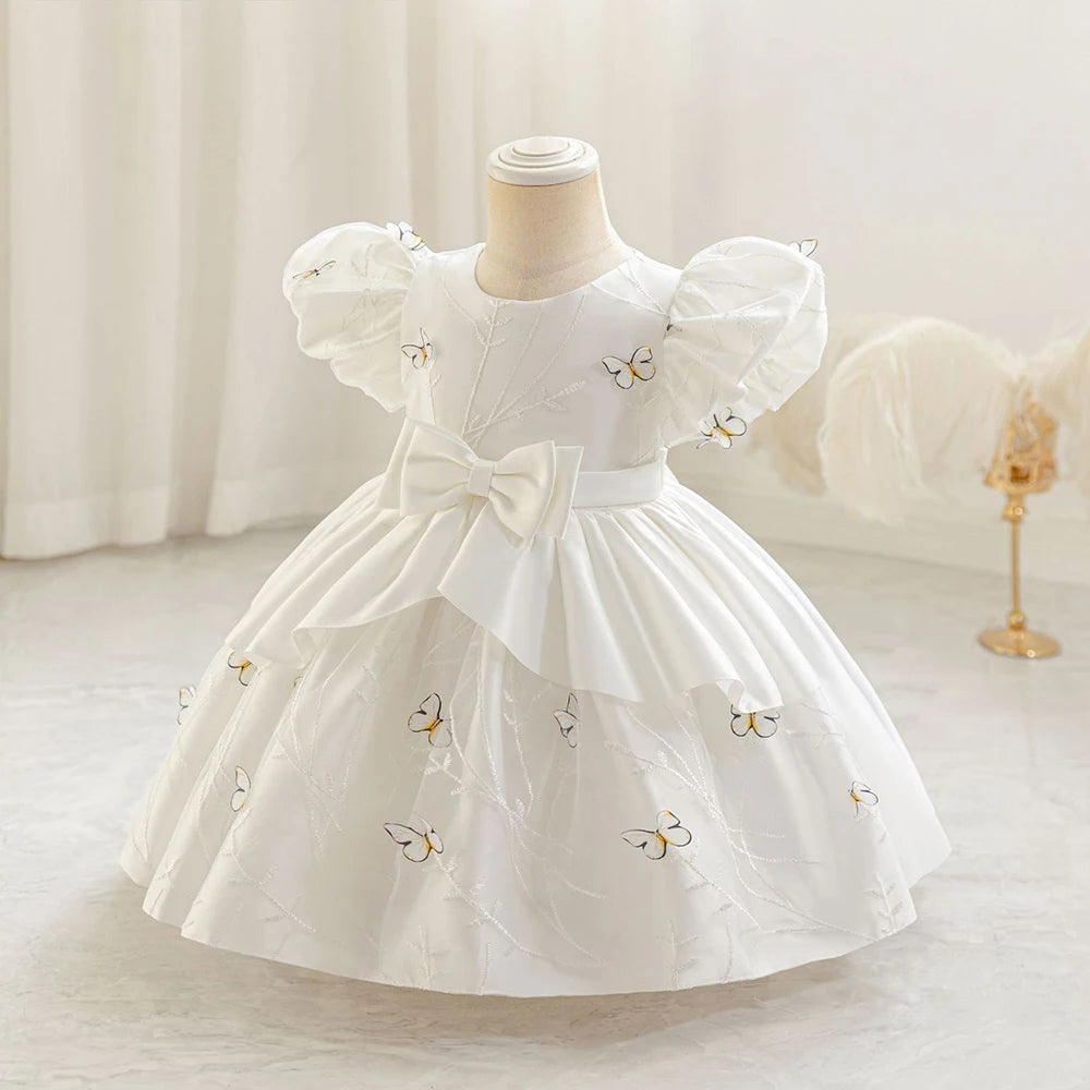 Robe bébé fille blanche à manches bouffantes et grand nœud à la taille, idéale pour baptême ou mariage