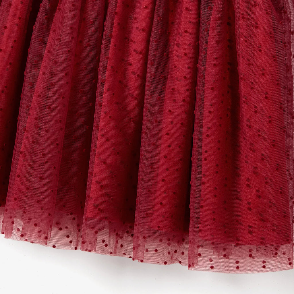 Détail du tulle plumetis rouge sur la jupe de la robe fille