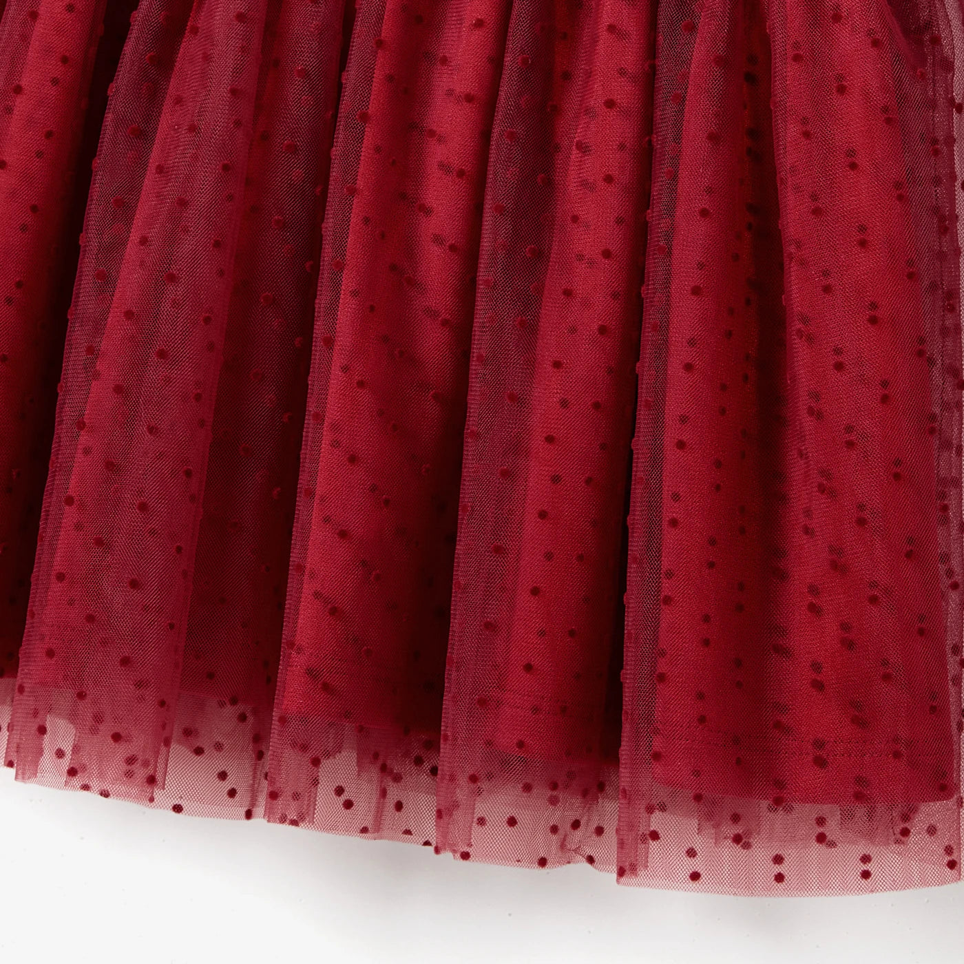 Détail du tulle plumetis rouge sur la jupe de la robe fille
