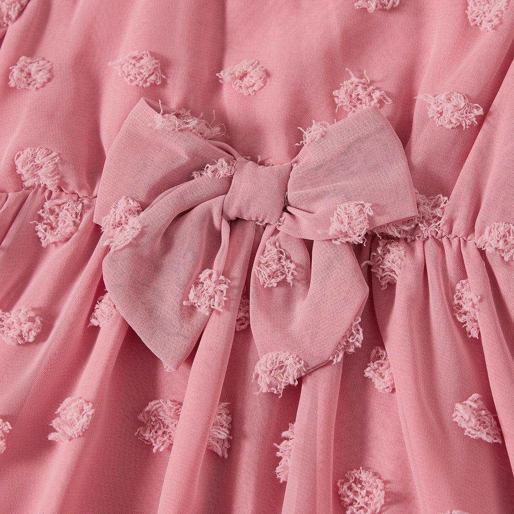 Gros plan sur le nœud décoratif à la taille de la robe rose mère et fille