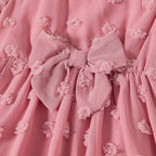 Gros plan sur le nœud décoratif à la taille de la robe rose mère et fille