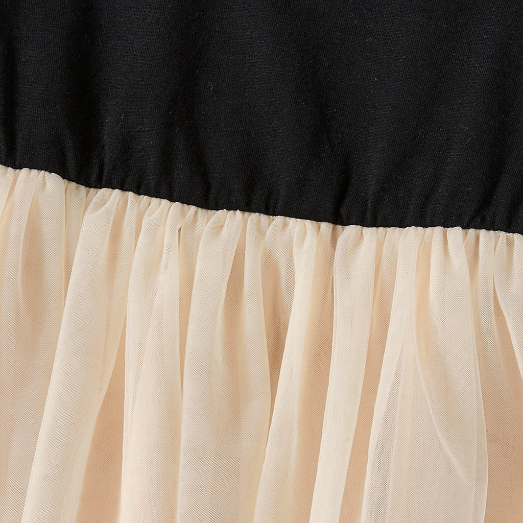 Détail de la couture entre le haut noir et la jupe beige en tulle