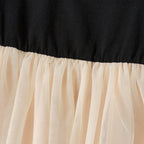 Détail de la couture entre le haut noir et la jupe beige en tulle