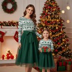 Robe mère fille de Noël assortie vert sapin et blanc avec motif rennes et flocons devant un sapin décoré