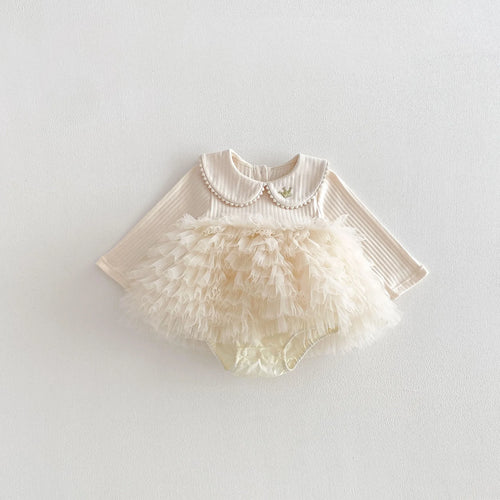 Détail du col Claudine perlé sur la barboteuse bébé beige