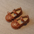 Ballerine beige avec noeud papillon portée par une petite fille