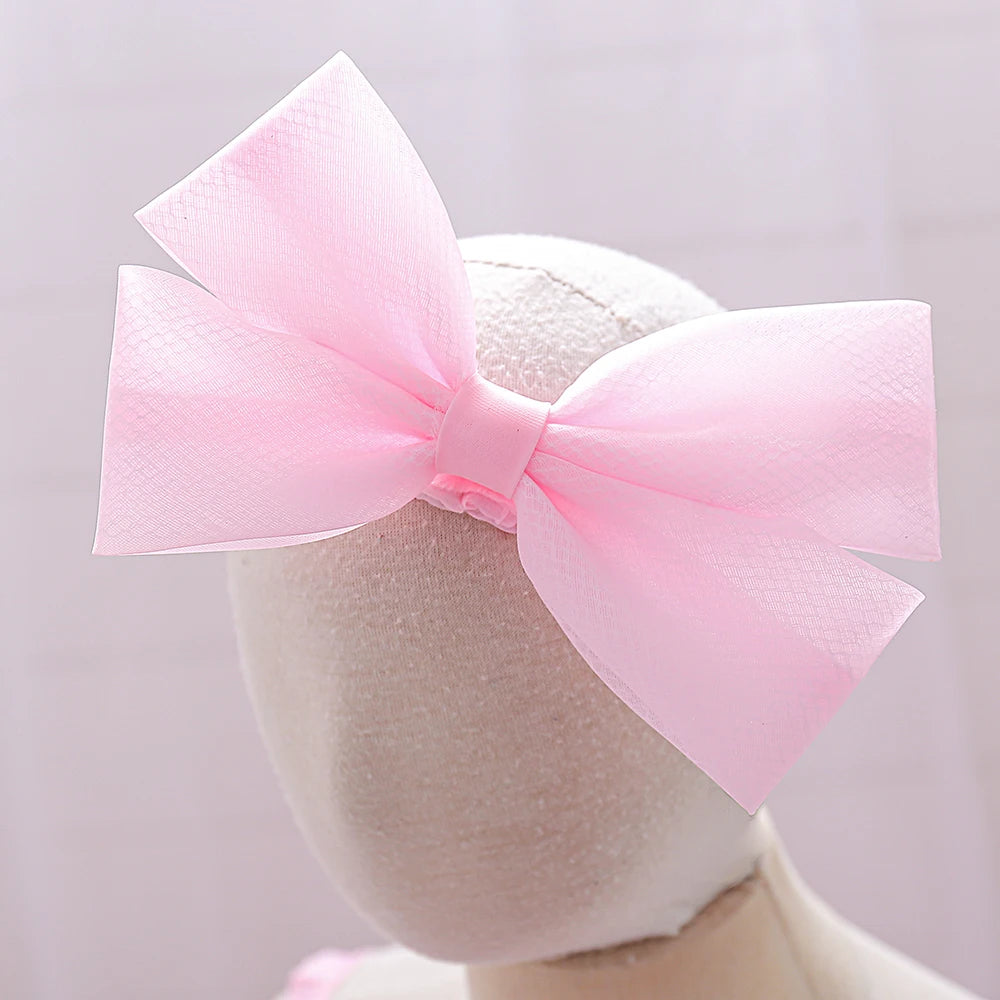 Détail du bandeau élastique avec grand nœud rose assorti à la robe Rosie