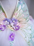 Gros plan sur l'accessoire de tête assorti à la robe avec fleurs violettes et détails papillon