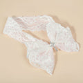 Bandeau de cérémonie Élina pour petite fille en dentelle blanche délicate avec un grand nœud orné d'une croix en perles