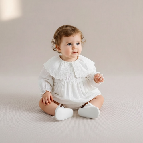 Barboteuse de baptême blanche pour bébé fille avec grand col en dentelle brodée.