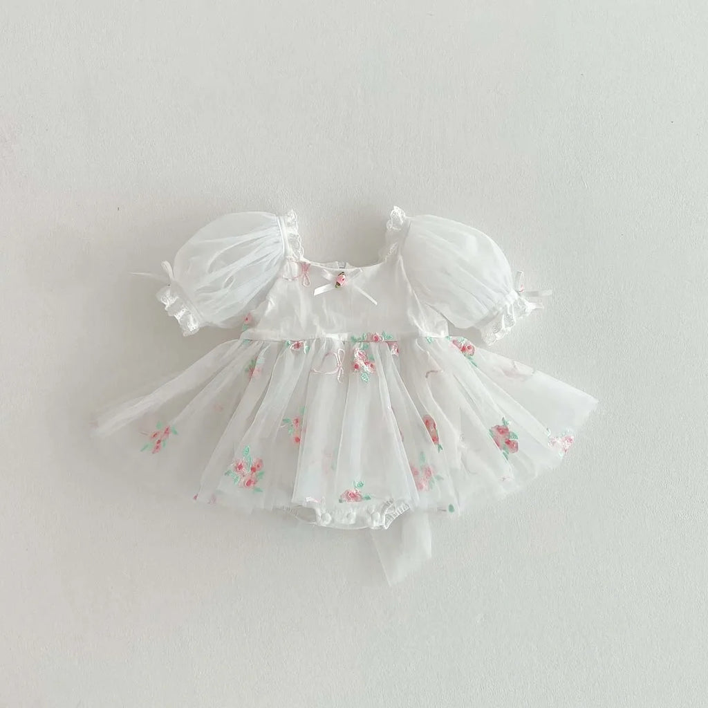 Barboteuse de baptême blanche en tulle aérien avec petites fleurs brodées.