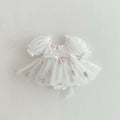 Barboteuse de baptême blanche en tulle aérien avec petites fleurs brodées.