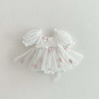 Barboteuse de baptême blanche en tulle aérien avec petites fleurs brodées.