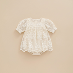 Vue de face à plat de la barboteuse-robe Milana beige montrant les motifs de fleurs brodées