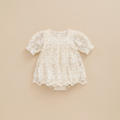 Vue de face à plat de la barboteuse-robe Milana beige montrant les motifs de fleurs brodées