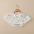 Détail d'un boléro en dentelle florale délicate pour tenue de cérémonie bébé