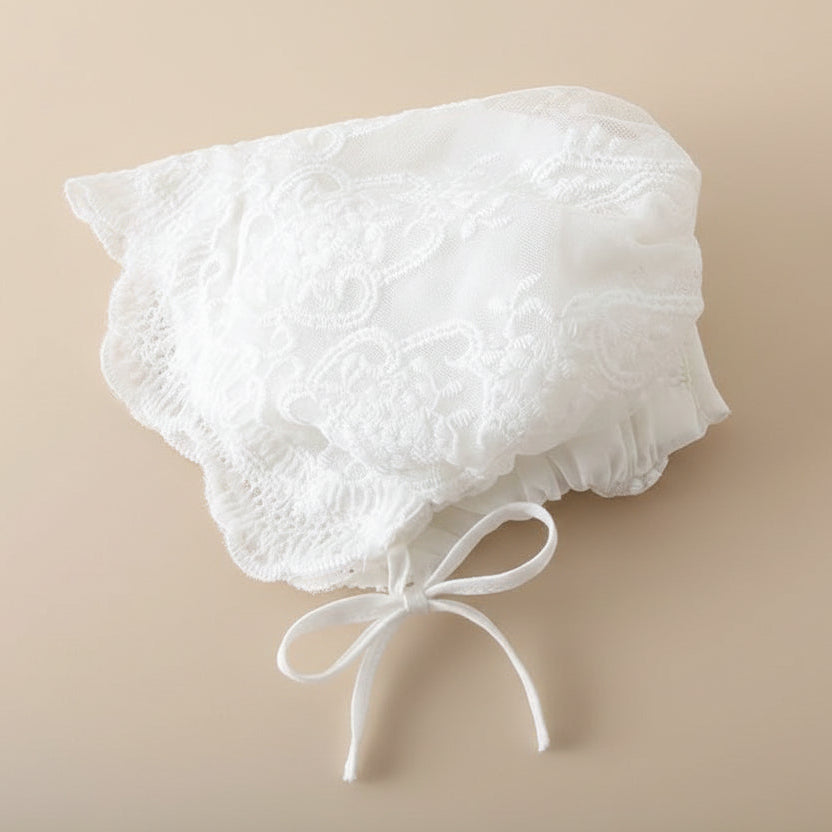 Détail du petit chapeau de baptême assorti avec broderies et rubans à nouer