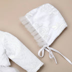 Détail du chapeau de baptême pour bébé en dentelle blanche avec rubans à nouer