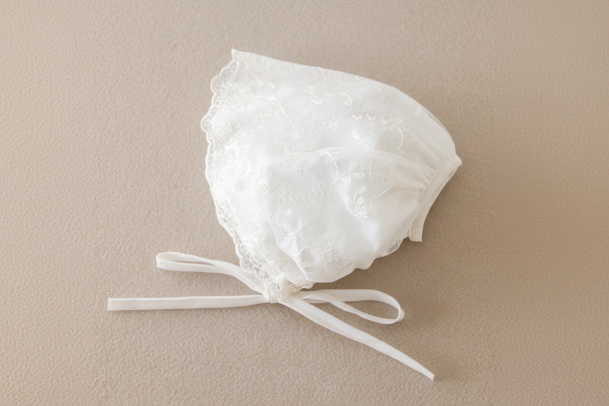 Accessoire de baptême : bonnet en dentelle blanche avec rubans à nouer pour bébé
