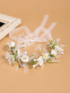 Zoom sur les longs rubans de dentelle et de satin blanc permettant d'ajuster la couronne de fleurs à l'arrière
