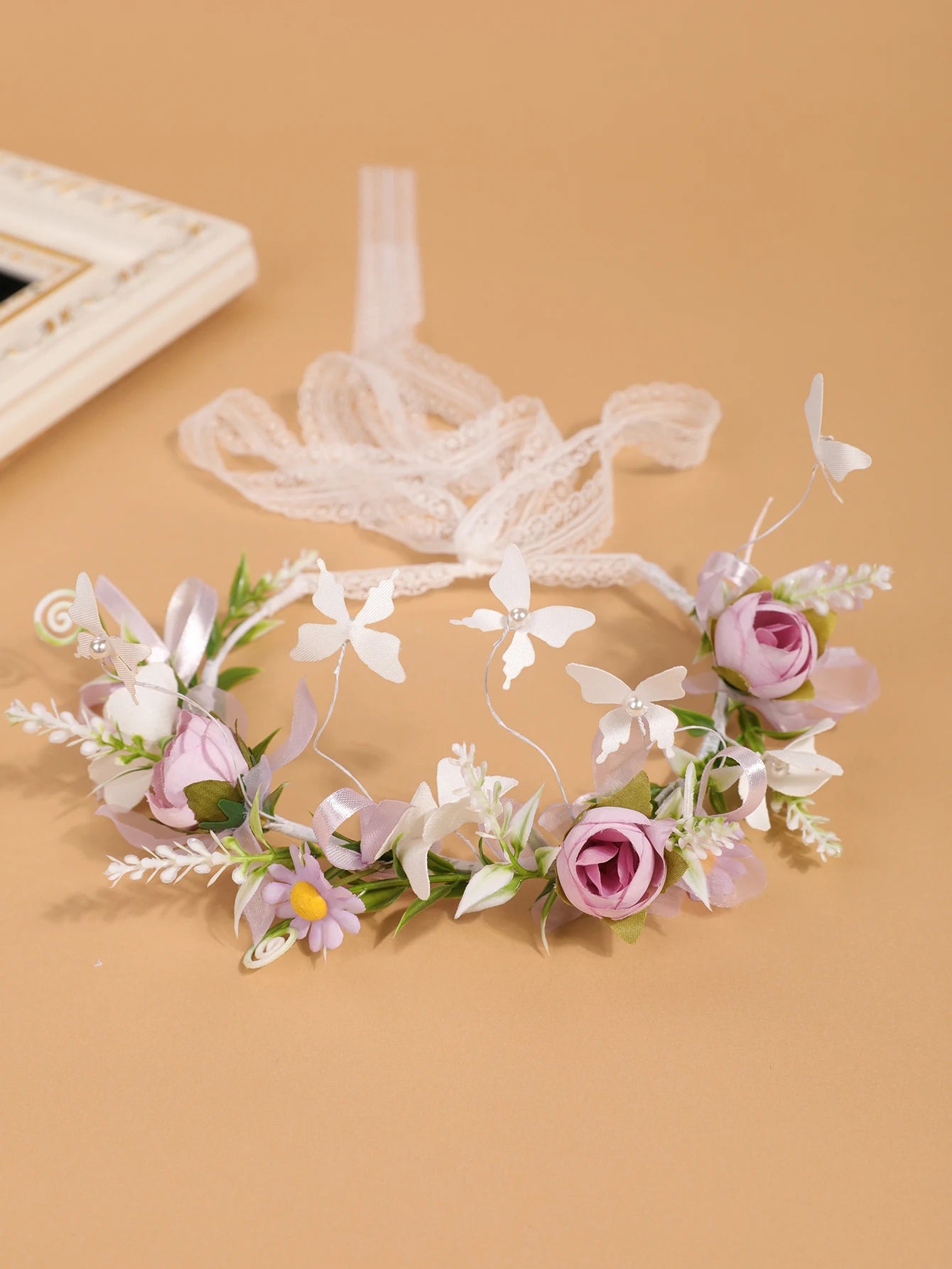Variante de la couronne Maïa avec fleurs roses et mauves, rubans assortis et petits papillons blancs