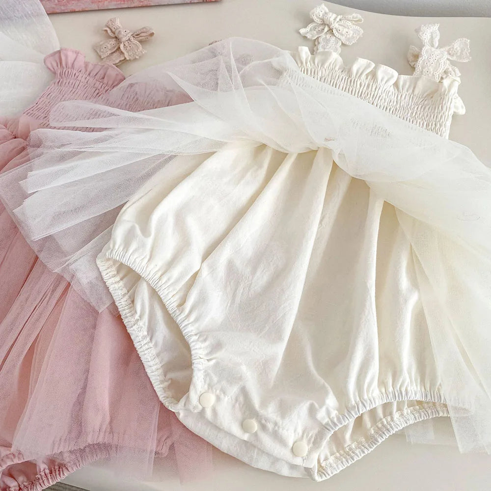 Gros plan sur l'entrejambe boutonné d'une barboteuse pour bébé en coton avec jupon en tulle souple, montrant les boutons pressions pour le change