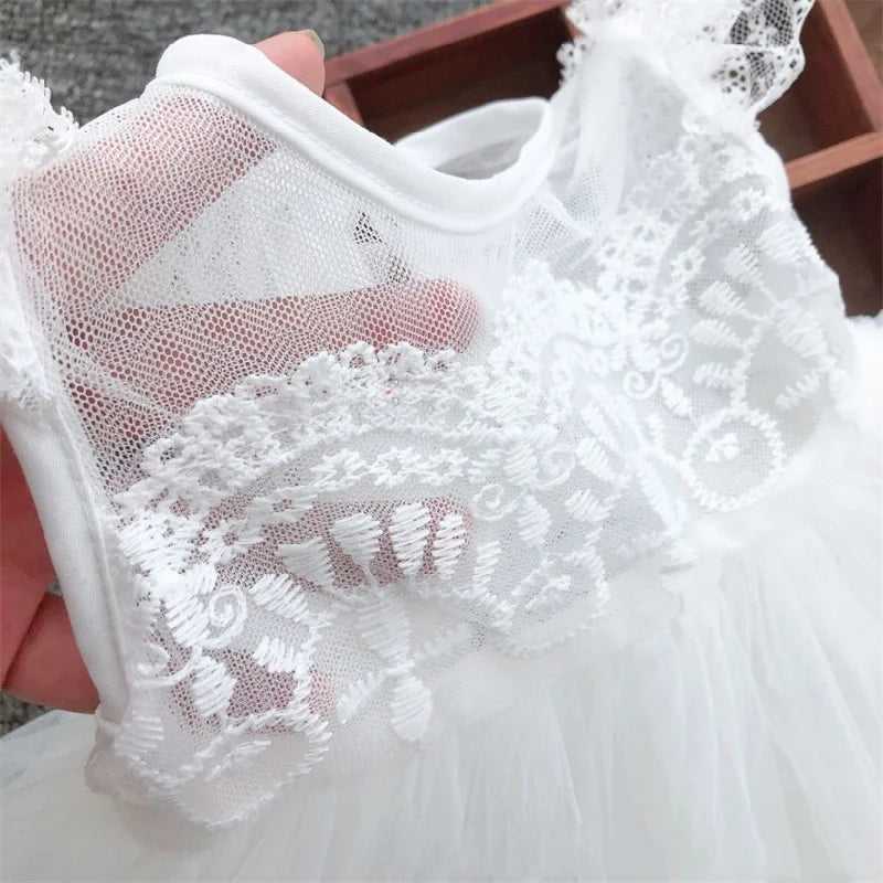 Gros plan sur le buste en transparence et les broderies délicates d'une robe de baptême
