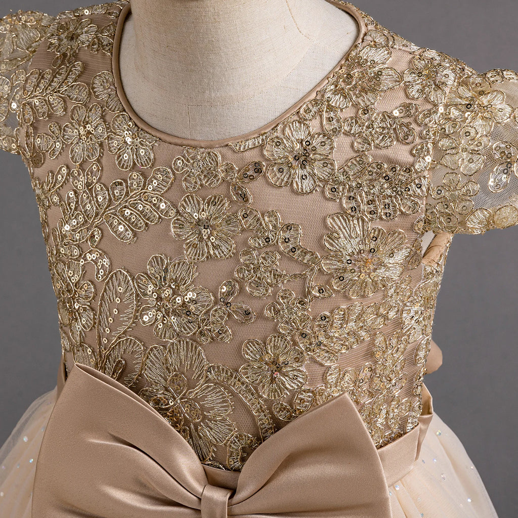 Gros plan sur les broderies dorées et les paillettes scintillantes du bustier